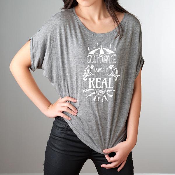 Close-up of grey slouchy bamboo-organic cotton women's tee with bold 'Climate Change is Real' print, sustainable fashion statement gift.