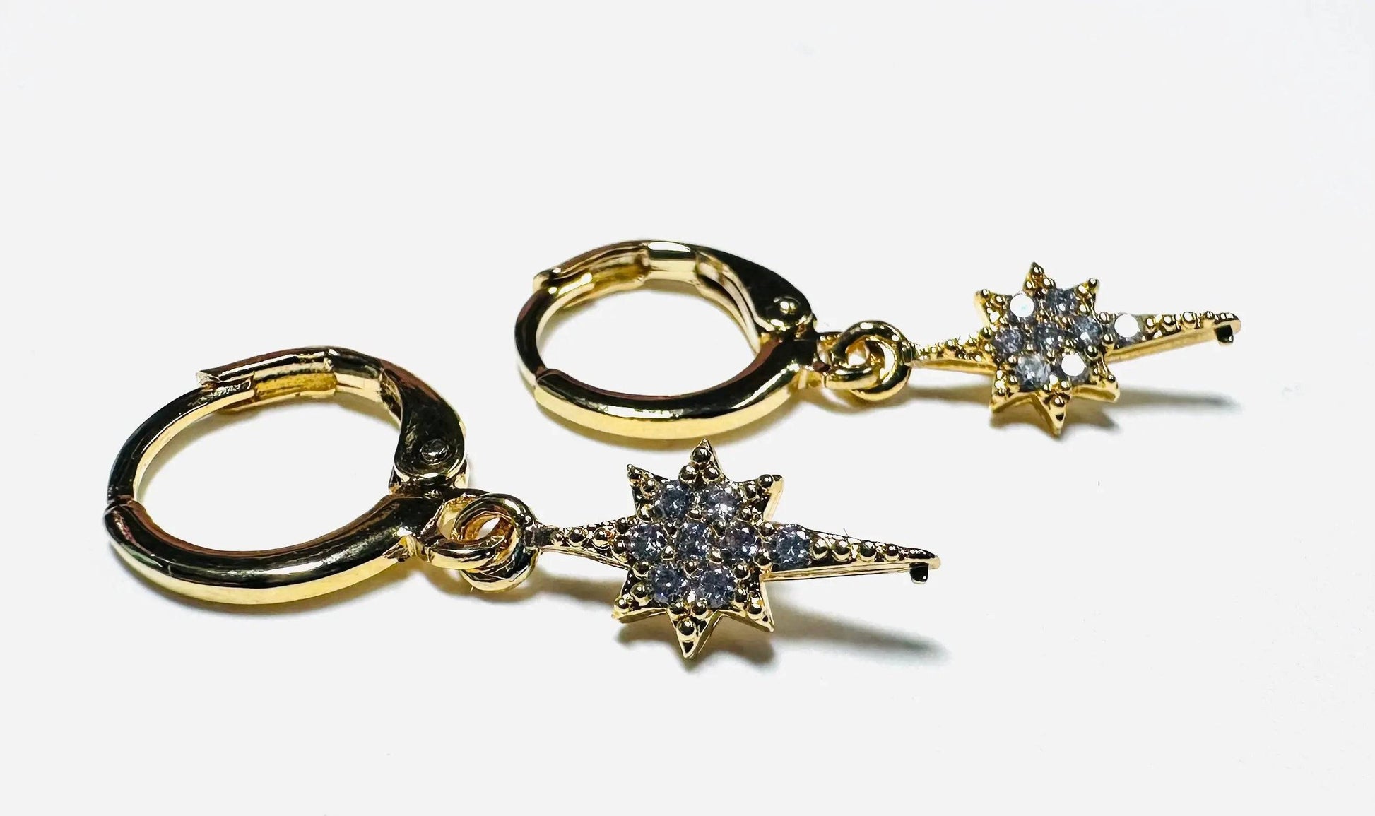 Gold Star Huggie Hoops with cubic zirconia detailing, ideal for celestial-themed fashion and everyday sparkle.
