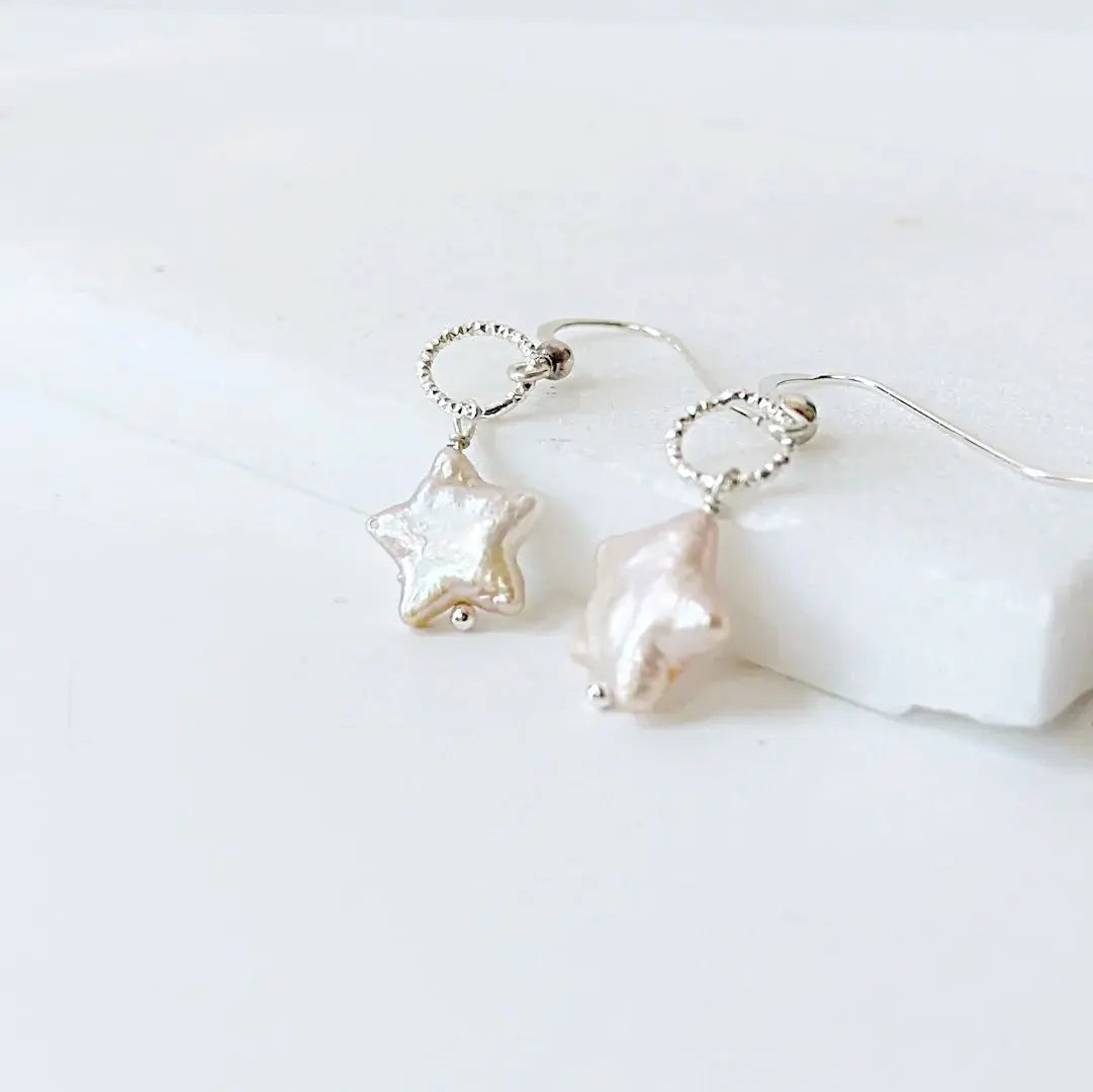 White star-shaped freshwater pearl earrings with silver wire wrapped loops. Delicate and modern jewelry for women.