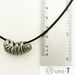 Tardigrade Necklace shown with ruler for scale. Features a small, detailed water bear charm on an adjustable black cord.