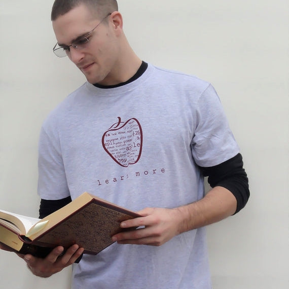 Man wearing grey Uni-T Inspirational Graphic Tee with multilingual apple design and 'learn more' slogan, classic fit teacher gift.
