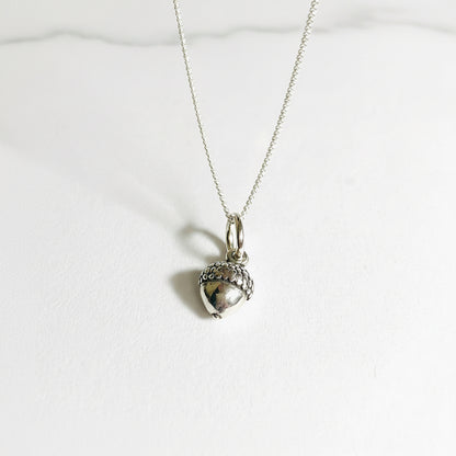 Tiny acorn charm necklace in sterling silver with a 16-inch chain, perfect fall accessory for nature lovers and gift giving.