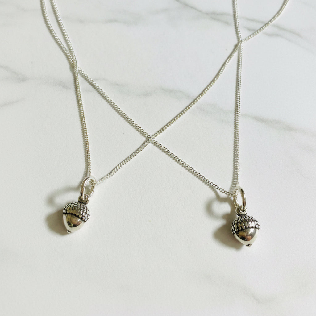 Pair of sterling silver tiny acorn charm necklaces with 16-inch chains, ideal nature-themed jewelry for fall or matching gifts.