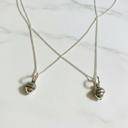 Pair of sterling silver tiny acorn charm necklaces with 16-inch chains, ideal nature-themed jewelry for fall or matching gifts.