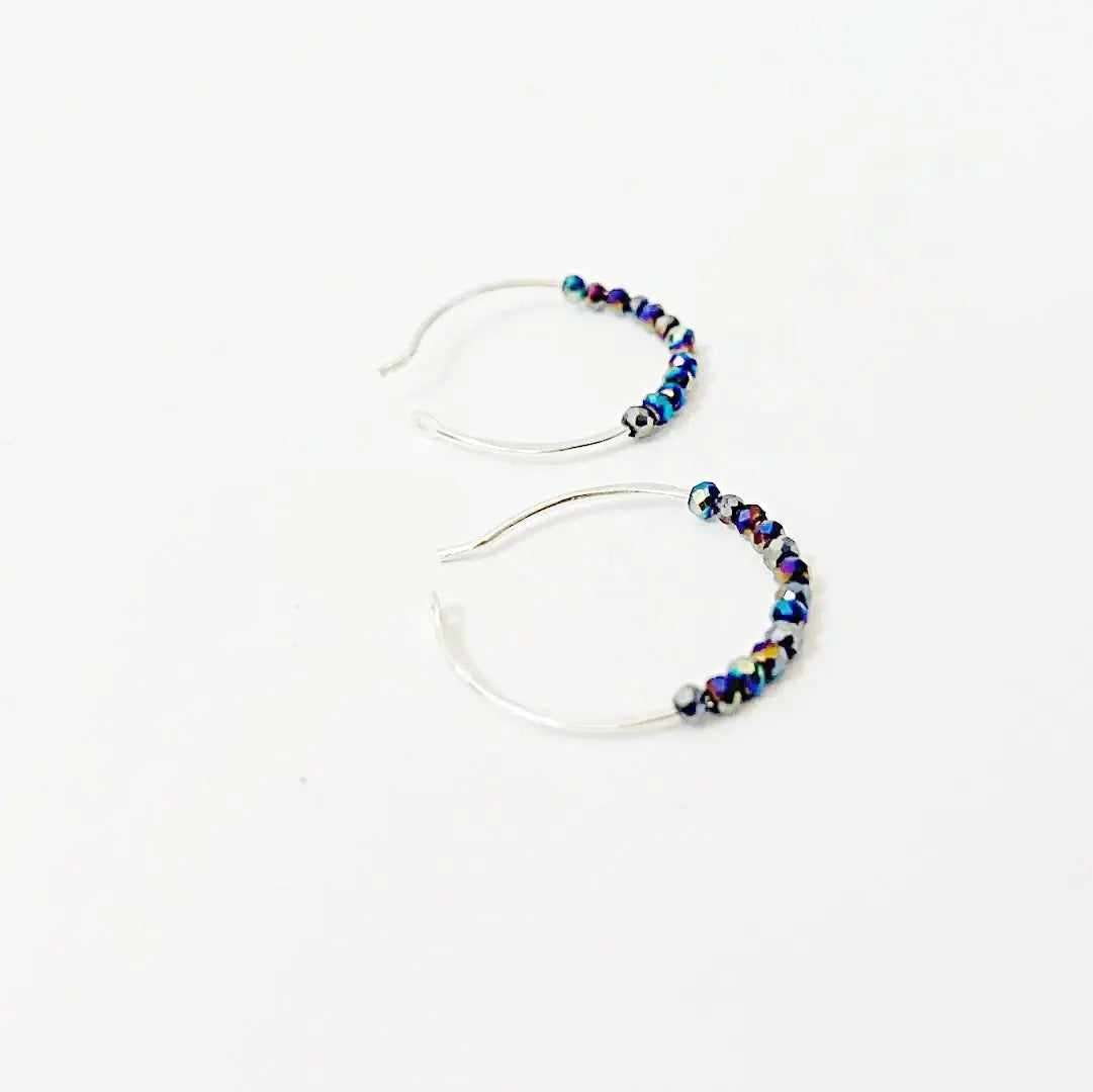 Close-up of blue crystal hoops on sterling silver, featuring shimmering beads. Perfect fashion accessory for sparkle and sophistication.