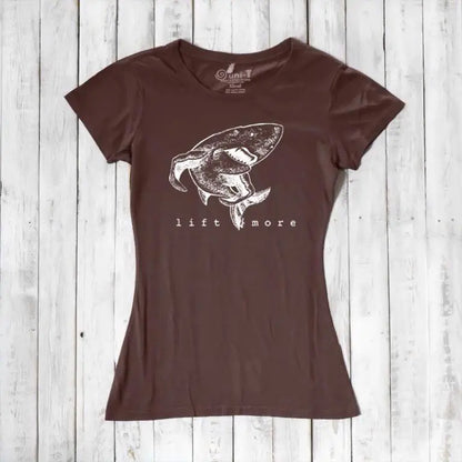 Brown eco-friendly women's T-shirt with shark and 'Lift More' graphic. Bamboo and organic cotton blend for gym and casual wear.