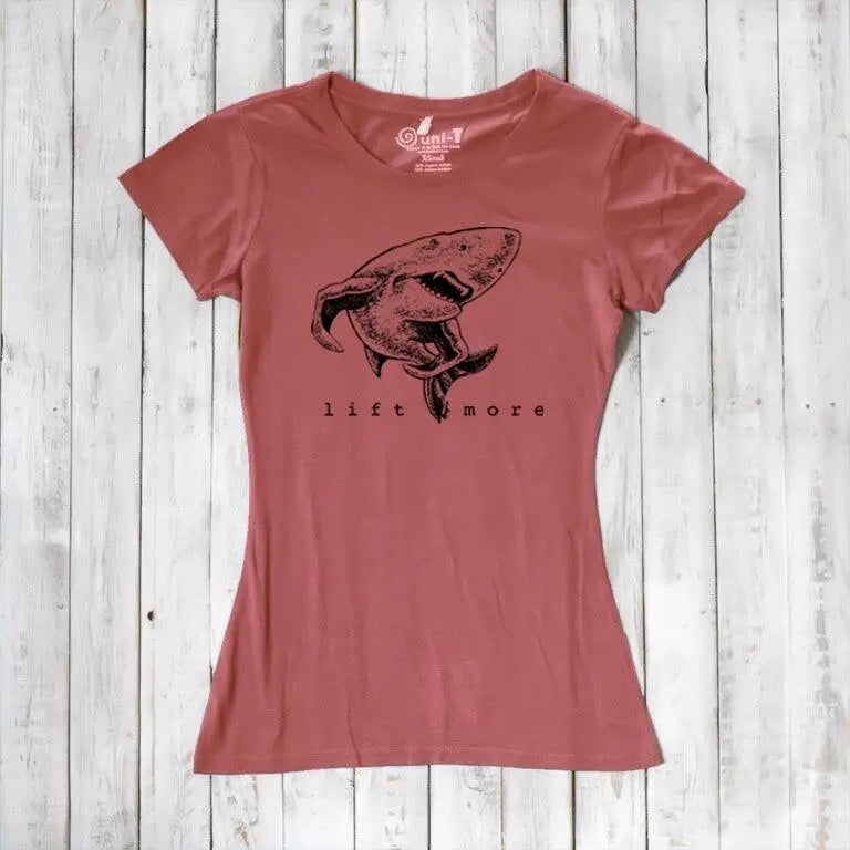 Rust red women's shark T-shirt with 'Lift More' print, crafted from bamboo and organic cotton. Sustainable gym motivation top.