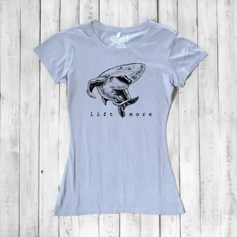Light blue women's shark graphic T-shirt with 'Lift More' text. Sustainable bamboo and organic cotton gym motivation tee.