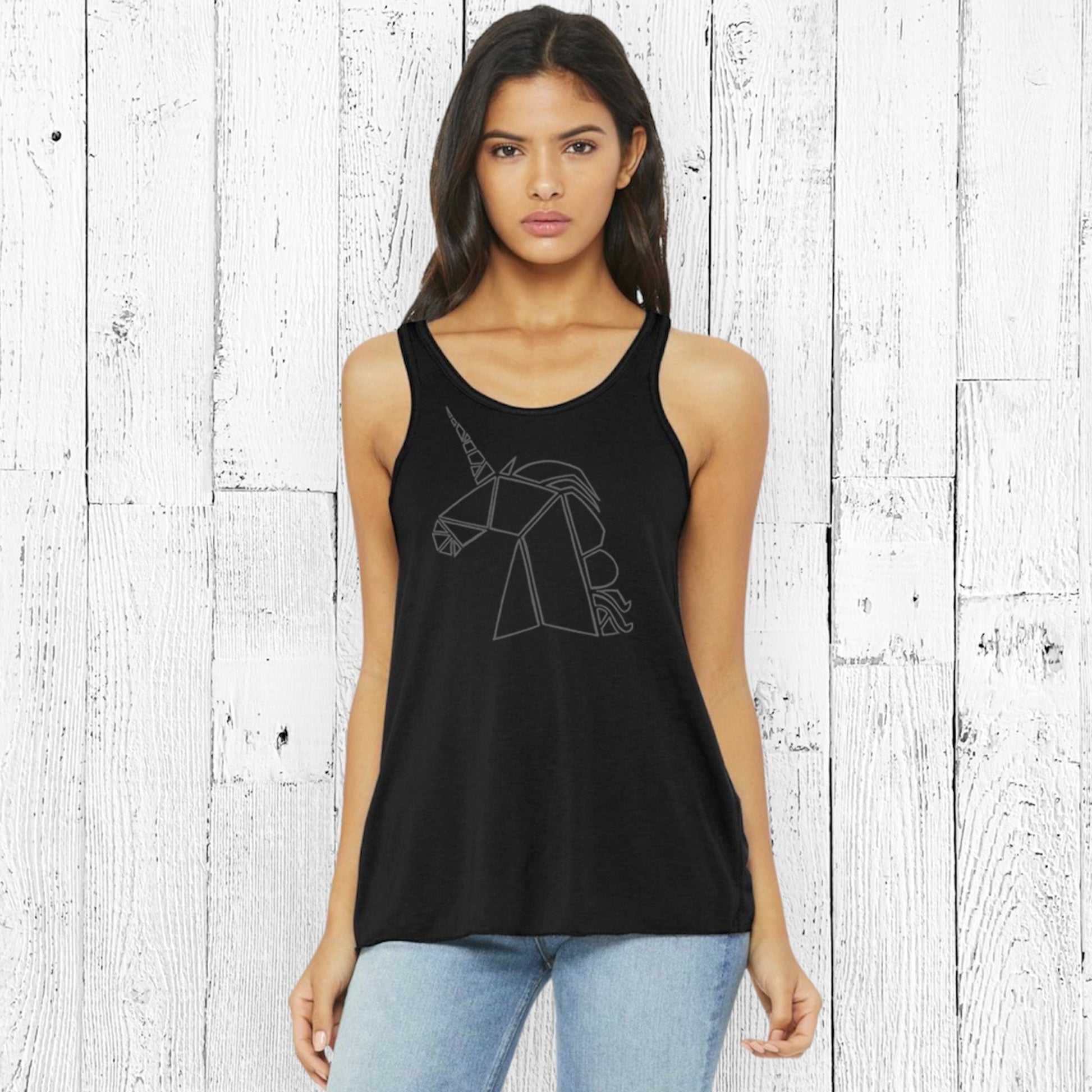 Black unicorn flowy tank top for women modeled with jeans. Features a magical unicorn design, ideal for fantasy apparel lovers.