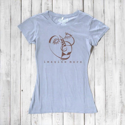 Light blue Women's Cubism Face T-Shirt in bamboo & organic cotton with brown abstract face design and 'imagine more' text. Artistic eco-friendly top.